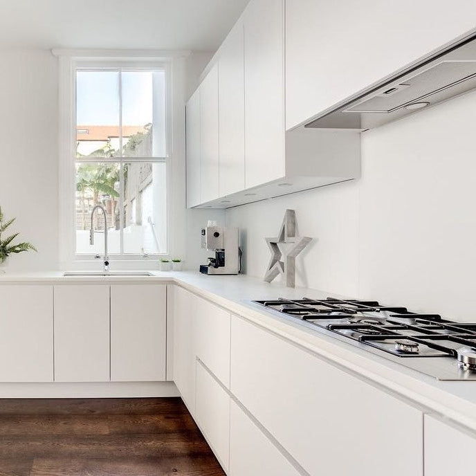 74cm stainless steel canopy built-in cooker hood installed in a modern white kitchen with handleless cabinets and gas hob