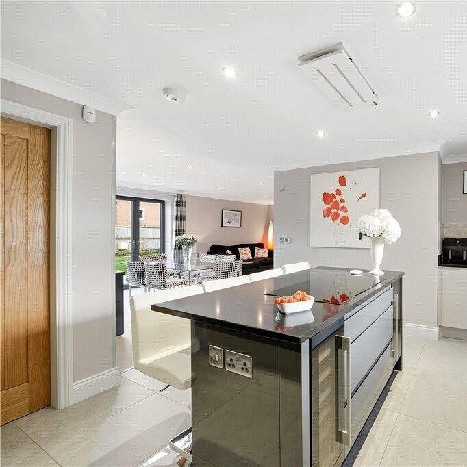 Modern open-plan kitchen featuring a 650mm white small ceiling extractor fan installed flush above a grey gloss kitchen island