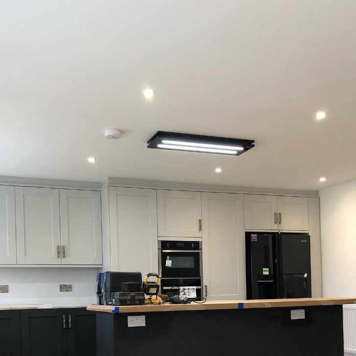 Luxair 800mm black slimline ceiling cooker hood with bright LED lighting panels, installed over a black kitchen island in a modern shaker-style kitchen