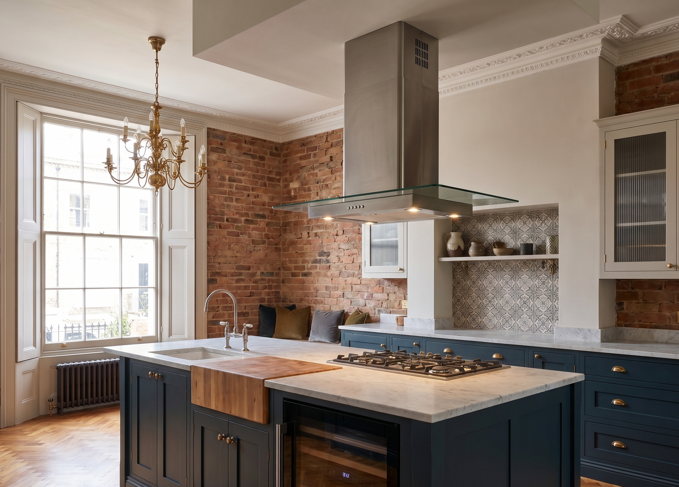 90cm stainless steel straight glass island cooker hood. Installed within a traditional style kitchen with wooden features and navy blue units.