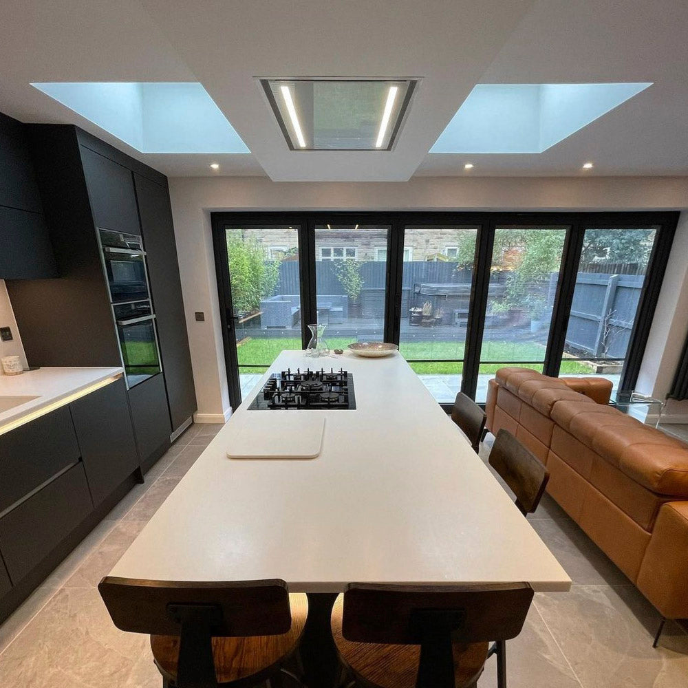 White 90cm x 60cm Celux Cooker Hood Within A Modern kitchen With a Large Island and Seating Area, Installed Within A Custom Box Housing