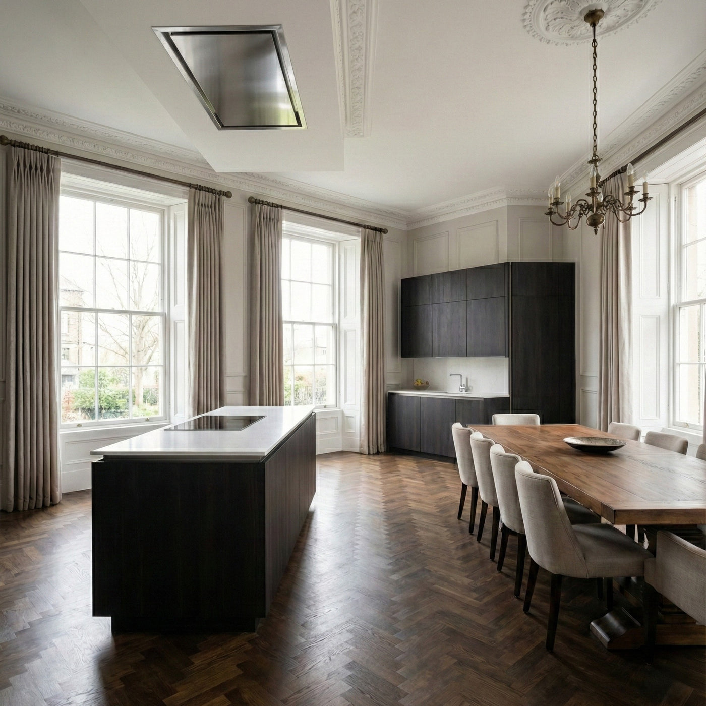 90cm x 30cm Stainless Steel Caporra Ceiling Cooker Hood Installed in a Modern kitchen with island, dining table, and chandelier 