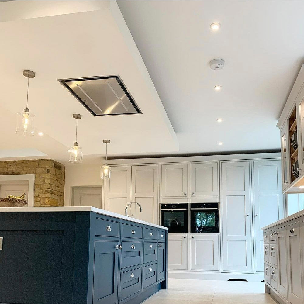 90cm Stainless Steel Celux Within A Modern kitchen with a dark island and white cabinets.