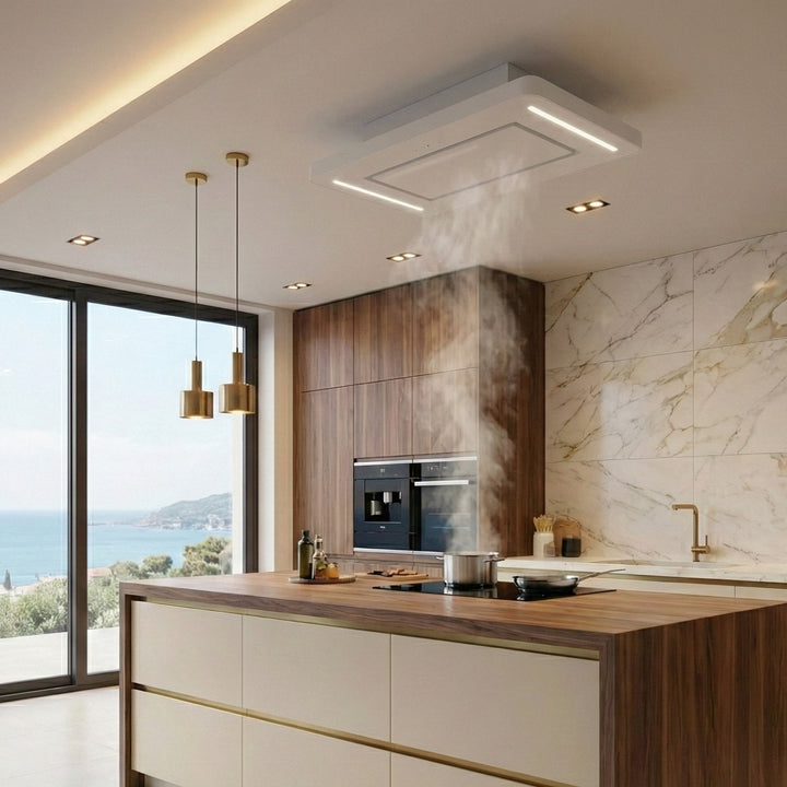 90cm Orion Recirculating Ceiling Cooker Hood Extracting In a Modern Kitchen With Marble Walls, Wooden Cabinets, and a Coastal View.