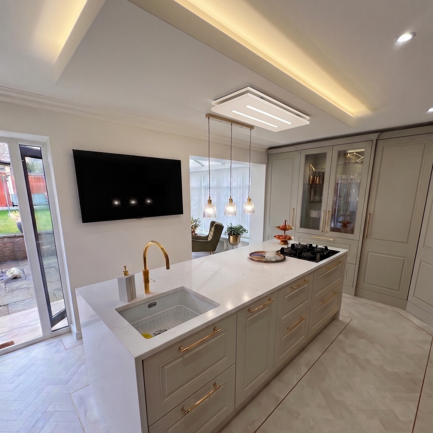 Luxair 80cm x 30cm cashmere small ceiling cooker hood in installed in a modern grey shaker kitchen with a white marble island and gold brass fixtures